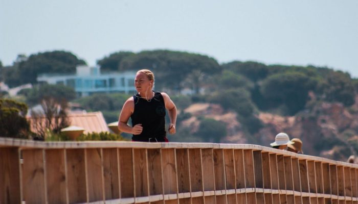 homem a fazer jogging na Praia da Torralta em Portimão